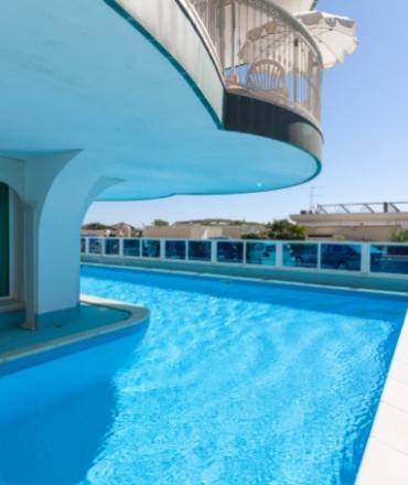 Piscina all'aperto con vista su terrazza e cielo sereno.